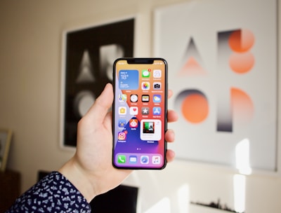 An illustration of a hand holding a smartphone displaying multiple game icons.